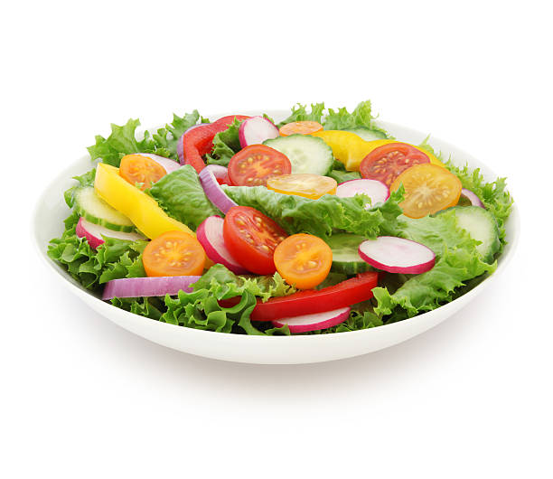 Colourful plate with green salad, red tomatoes, and yellow peppers